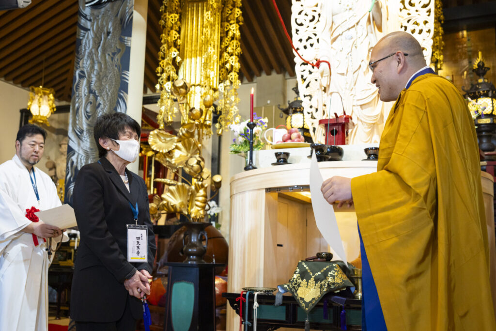 倉島住職から感謝状を贈られる亀井佳代子さん(撮影:浅田政志氏)